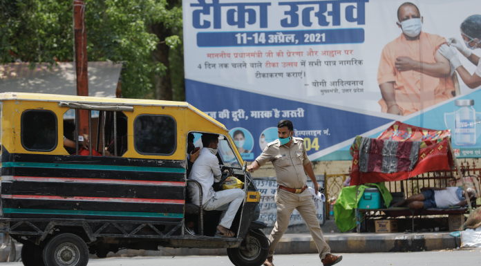 A police man stops an auto rickshaw in India