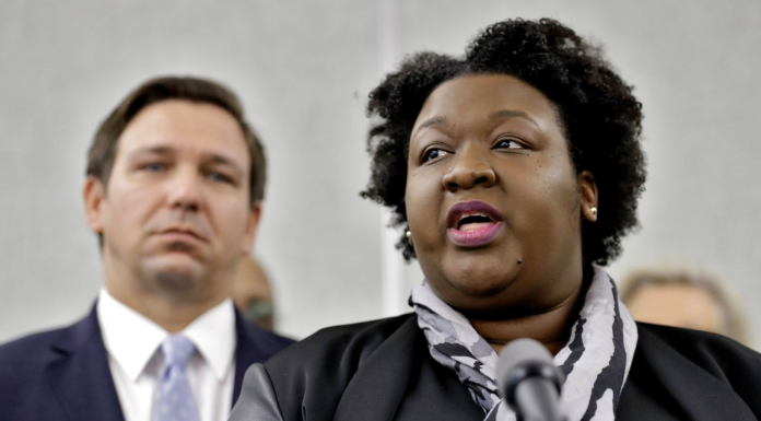 Florida Deputy Secretary for Health Dr. Shamarial Roberson, right, speaks to the media as Florida Gov. Ron DeSantis looks on during a news conference Monday, March 2, 2020, in Tampa. [ CHRIS O'MEARA | AP ]