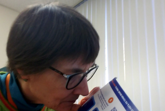 Woman sniffs a card designed to test whether someone has lost their sense of smell.