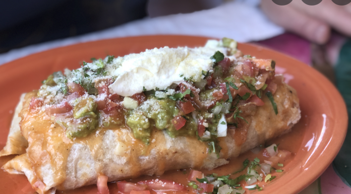 Macho Burrito (Rice, refried beans, choice of meat, topped with cheese guacamole, sour cream, onions, cilantro and tomatoes)