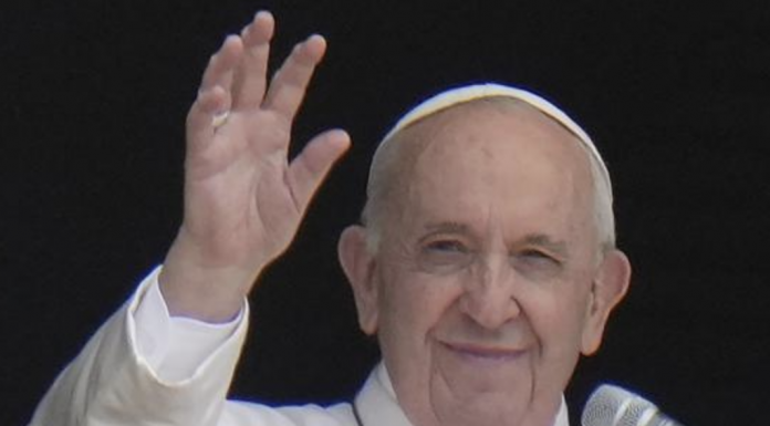 Pope Francis waves to the crowd as he arrives to recite the Angelus noon prayer from the window of his studio overlooking St.Peter's Square.