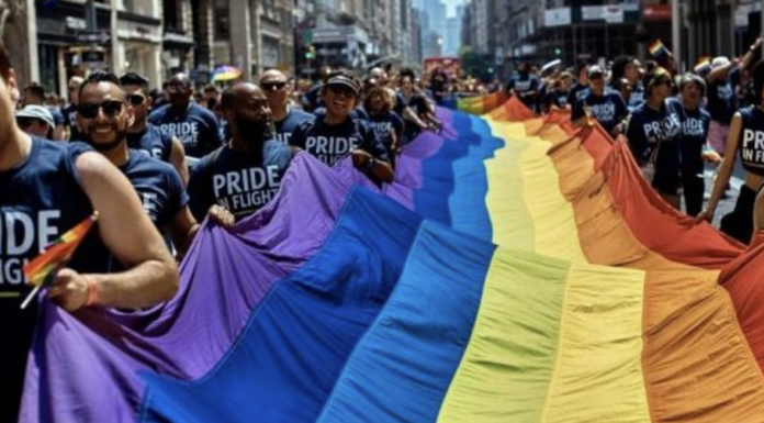 LGBTQ activists parade down street.