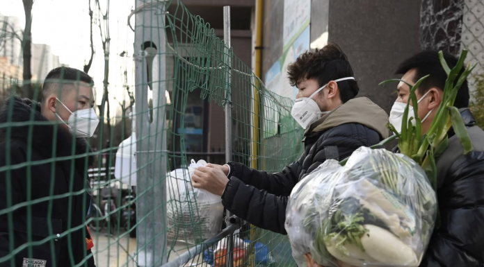 A volunteer receives daily necessities on behalf of residents under home quarantine in Xi'an, capital of northwest China's Shaanxi Province, Jan. 12, 2022.