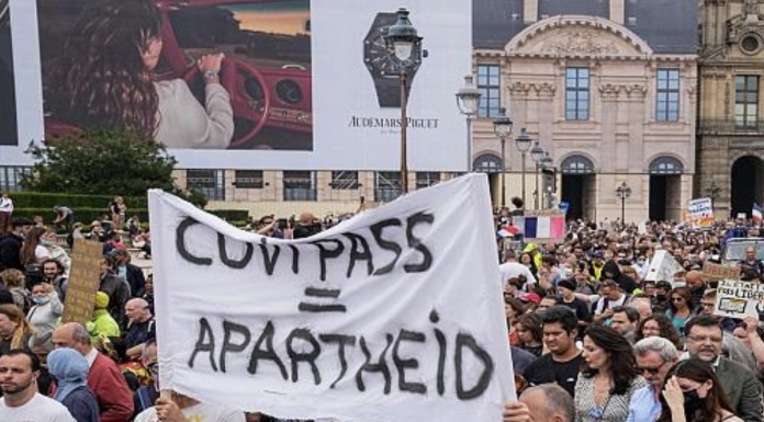 Anti-vaccine protesters holds a banner that reads health pass equal apartheid