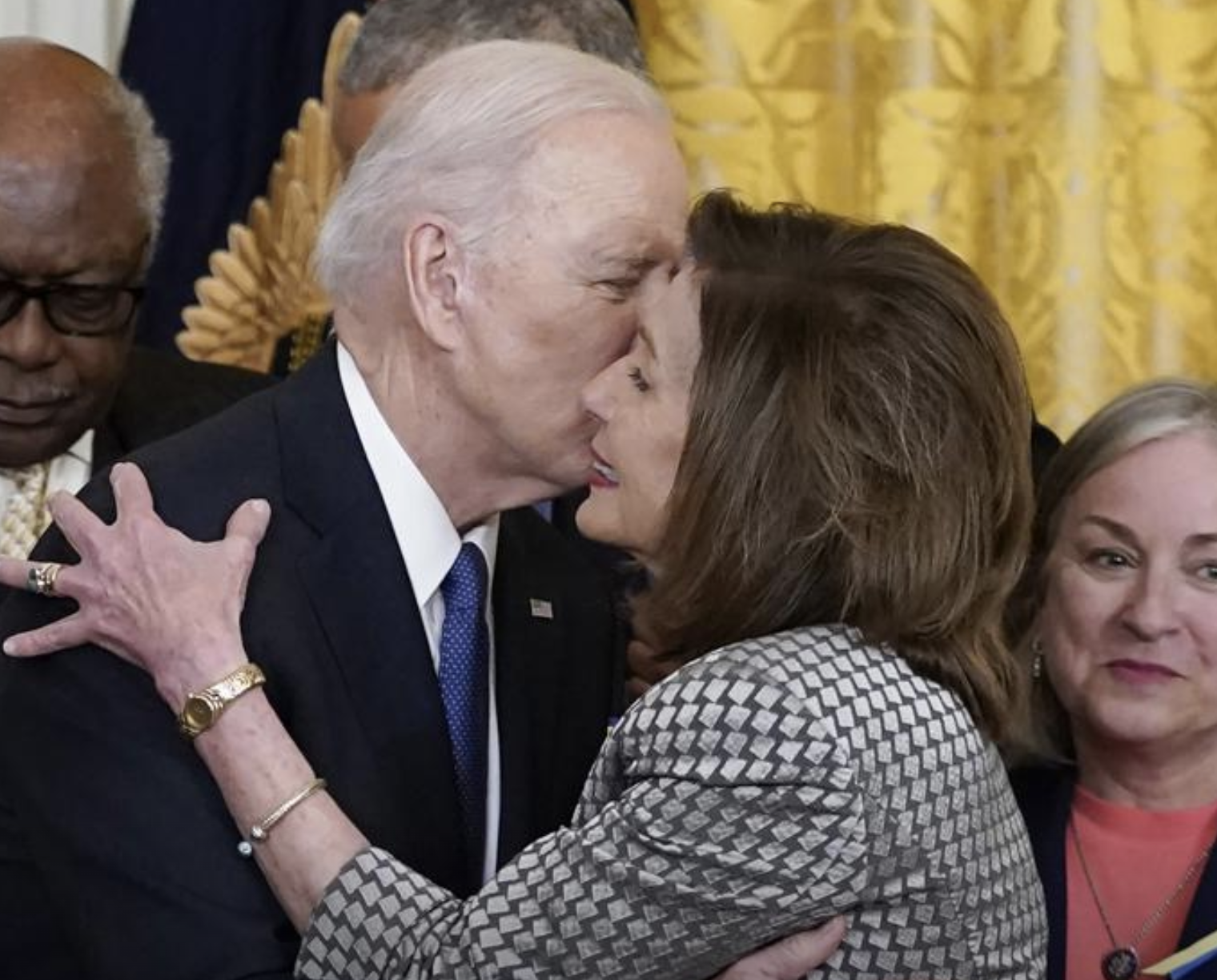 President Joe Biden kisses House Speaker Nancy Pelosi of Calif., during an Affordable Care Act event in the East Room of the White House in Washington, Tuesday, April 5, 2022. At left is House Majority Whip James Clyburn, D-S.C., and right is Rep. Susan Wild, D-Pa. Pelosi has tested positive for COVID-19 and is currently asymptomatic, her spokesman Drew Hammill said in a tweet Thursday, April 7. (AP Photo/Carolyn Kaster)