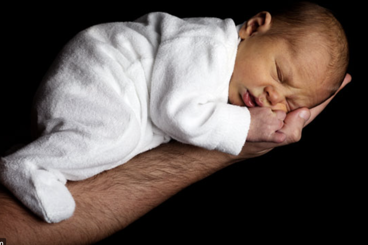 Baby sleeping on adult's arm