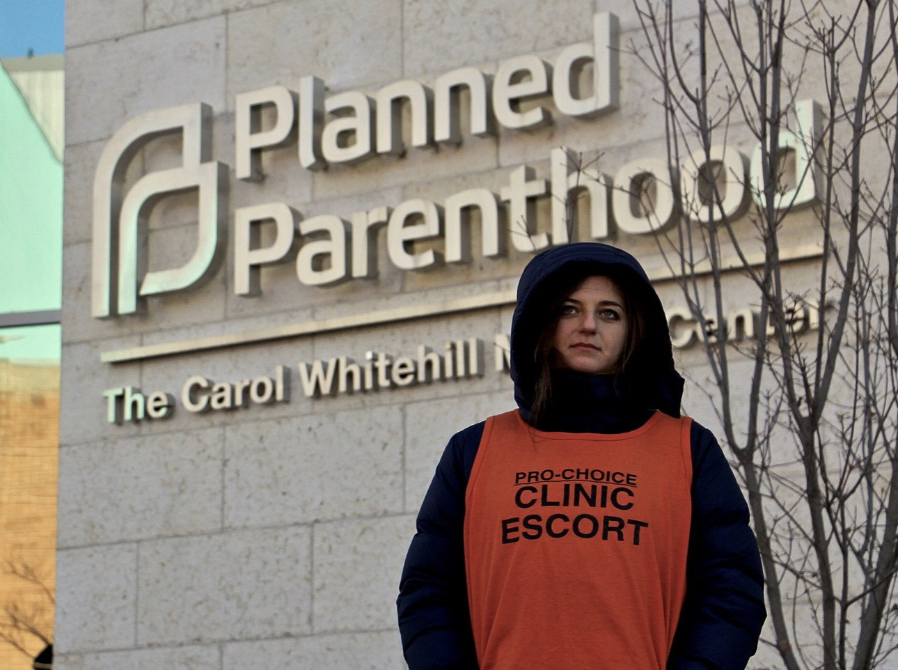 Abortion aide standing in front of Planned Parenthood sign