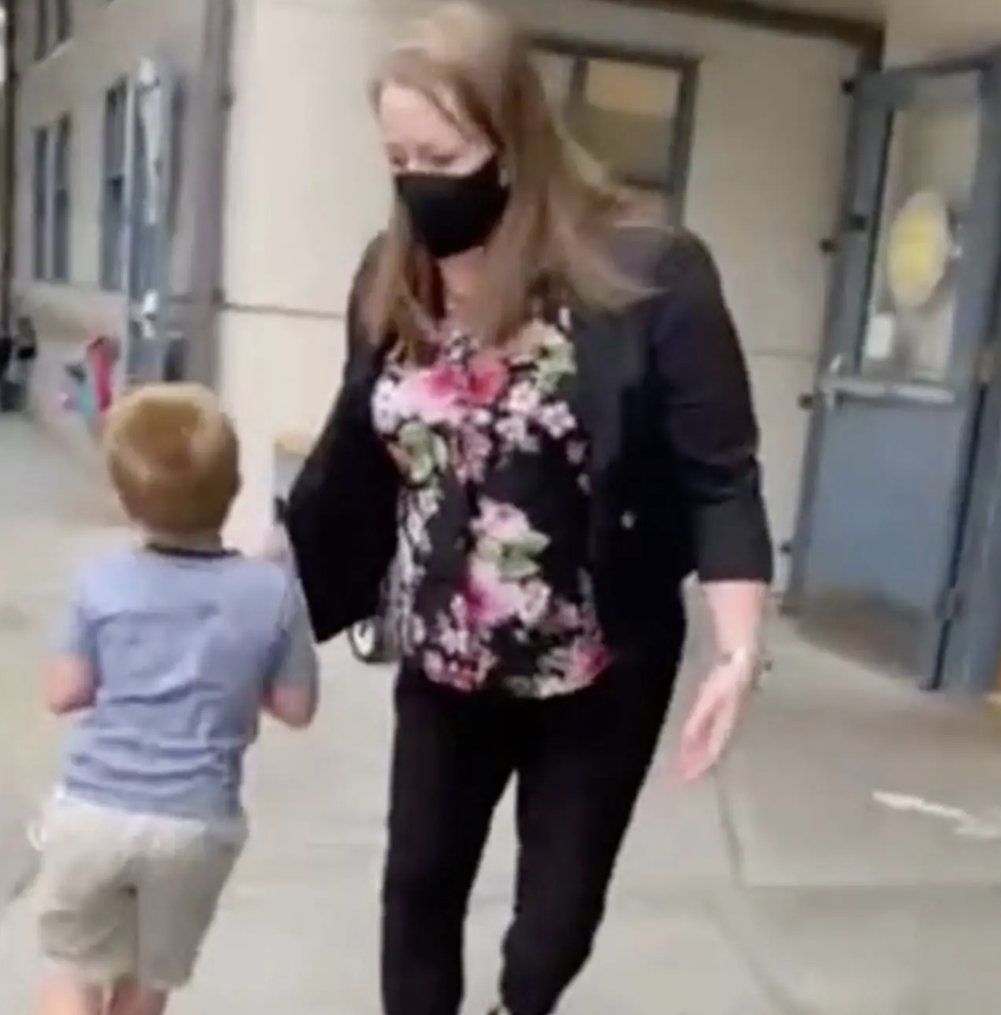 Masked teacher escorts unmasked student out of school to waiting cops.