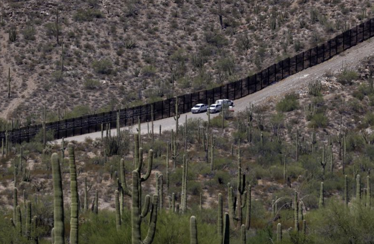 U.S. Customs and Patrol Patrol agents sit along a section of the international border wall that runs through Organ Pipe Cactus National Monument