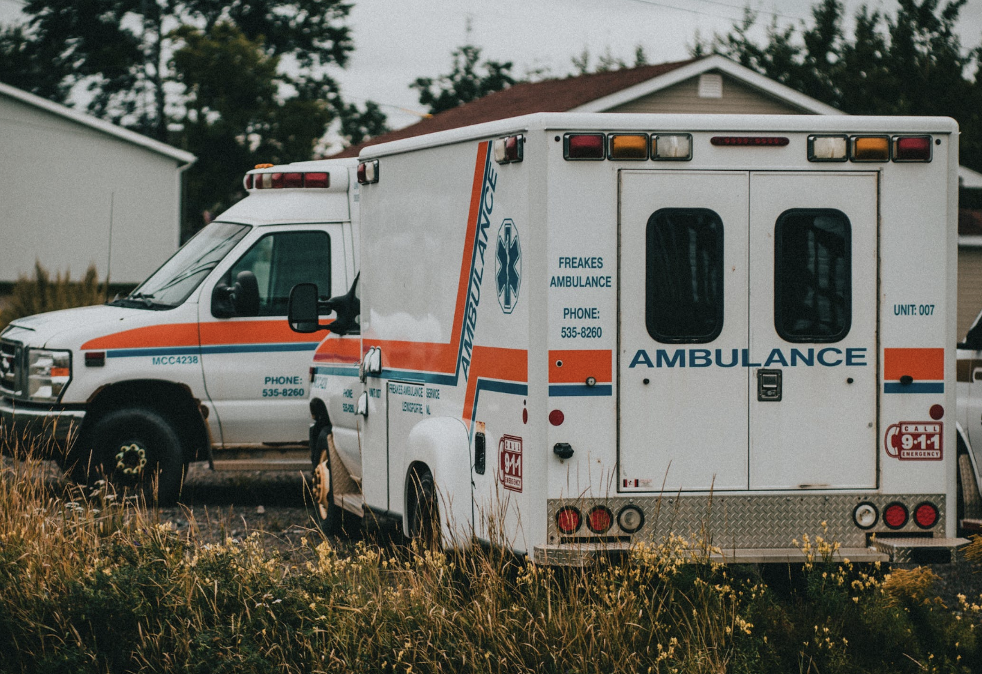 Two ambulances parked in a grassy area