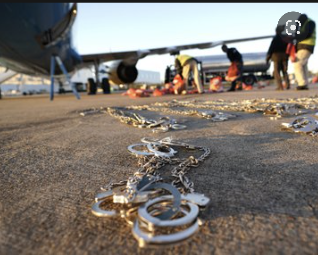 Restraints lie on the tarmac as personal belongings of immigrants who entered the United States illegally are loaded onto a plane