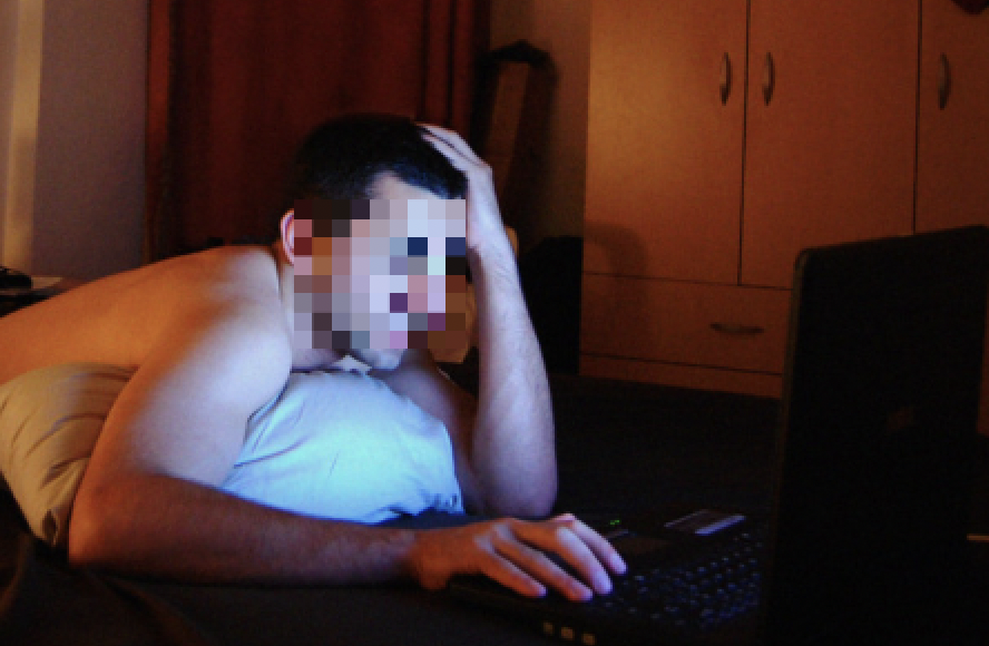 Man looking at a screen in a dark room