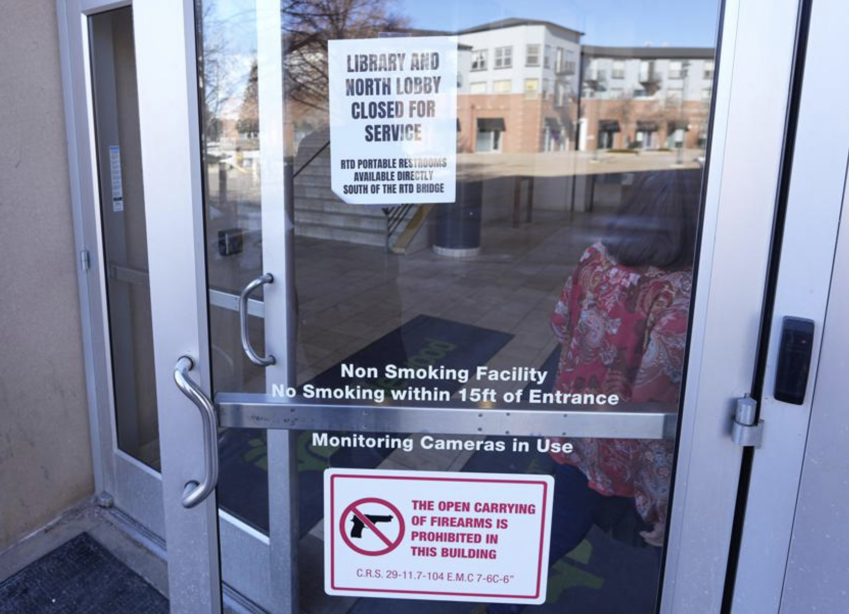 Signs are placed on the outside doors of city hall to advise visitors that the library as well as a restroom are closed because of meth contamination Thursday, Jan. 12, 2022, in the south Denver suburb of Englewood, Colo.