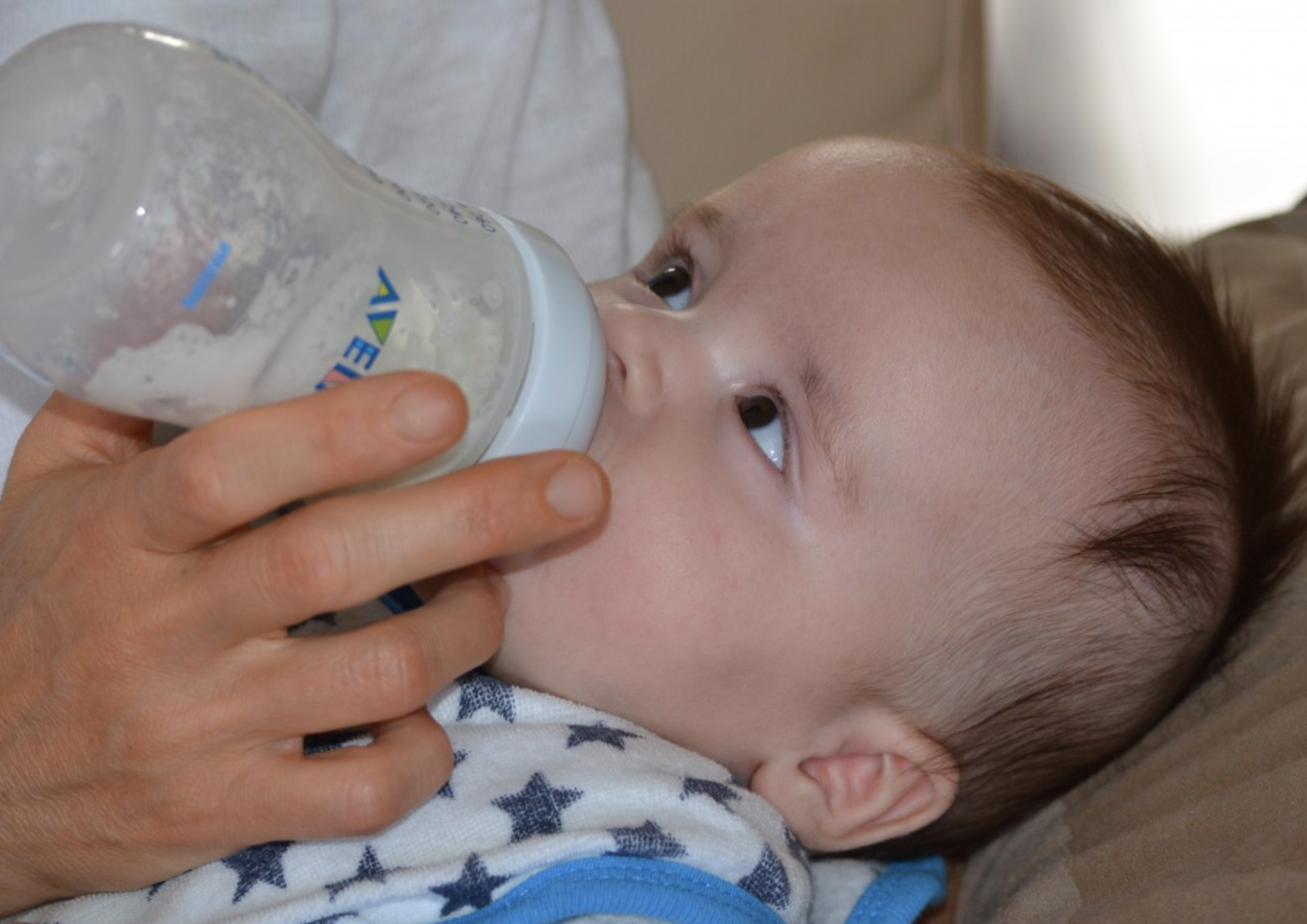 Infant drinking from a bottle