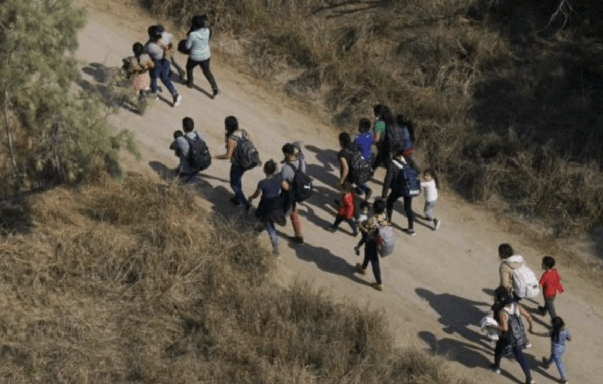 Illegal immigrants walk on a dirt road