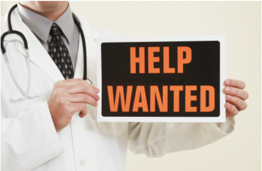 Doctor holding HELP WANTED sign
