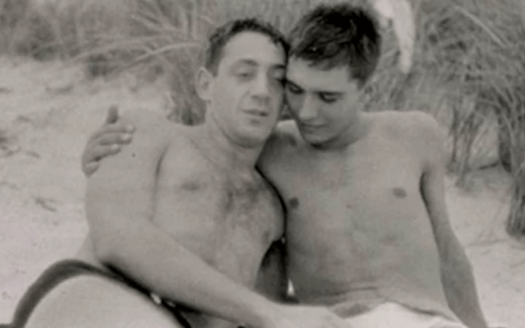 Harvey Milk (left) relaxes with his boyfriend, Joe Campbell, on New York's Fire Island in September 1956. / PHOTO: San Francisco History Center, San Francisco Public Library