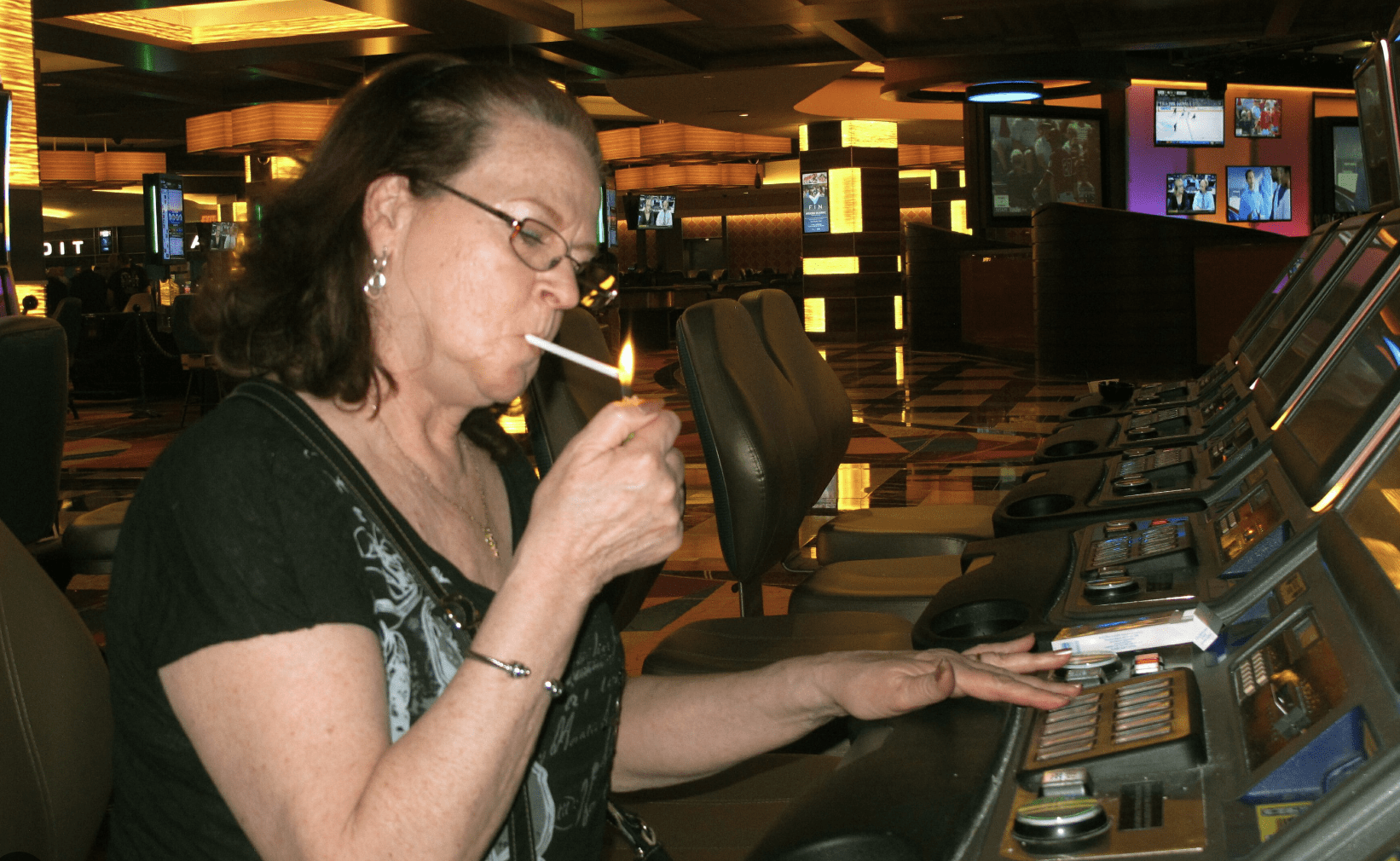 A woman lights a cigarette in the Tropicana casino in Atlantic City, NJ | AP photo